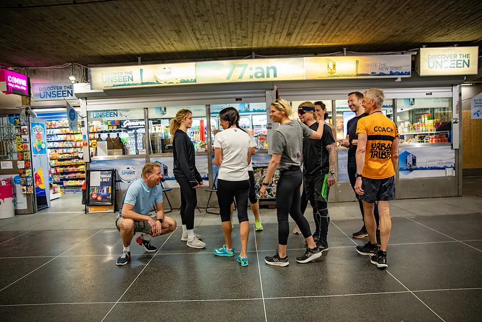 En grupp i träningskläder samlas med coachen innan passet i en gång i Stockholm