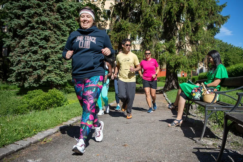 En grupp joggar längs en parkväg mitt på dagen